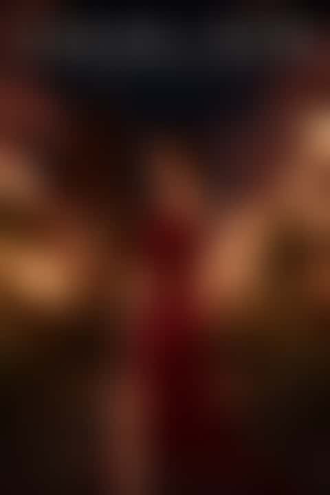 Movie poster reading SAKURA NOIR and EVERY PETAL HIDES A BLADE: a woman in a crimson satin gown looks back over her shoulder on lantern-lit temple steps in Kyoto as cherry blossom petals swirl