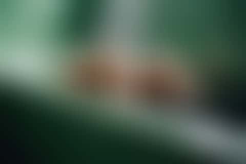 A slow, steam-filled shot in a green enamel room, two people barely moving.