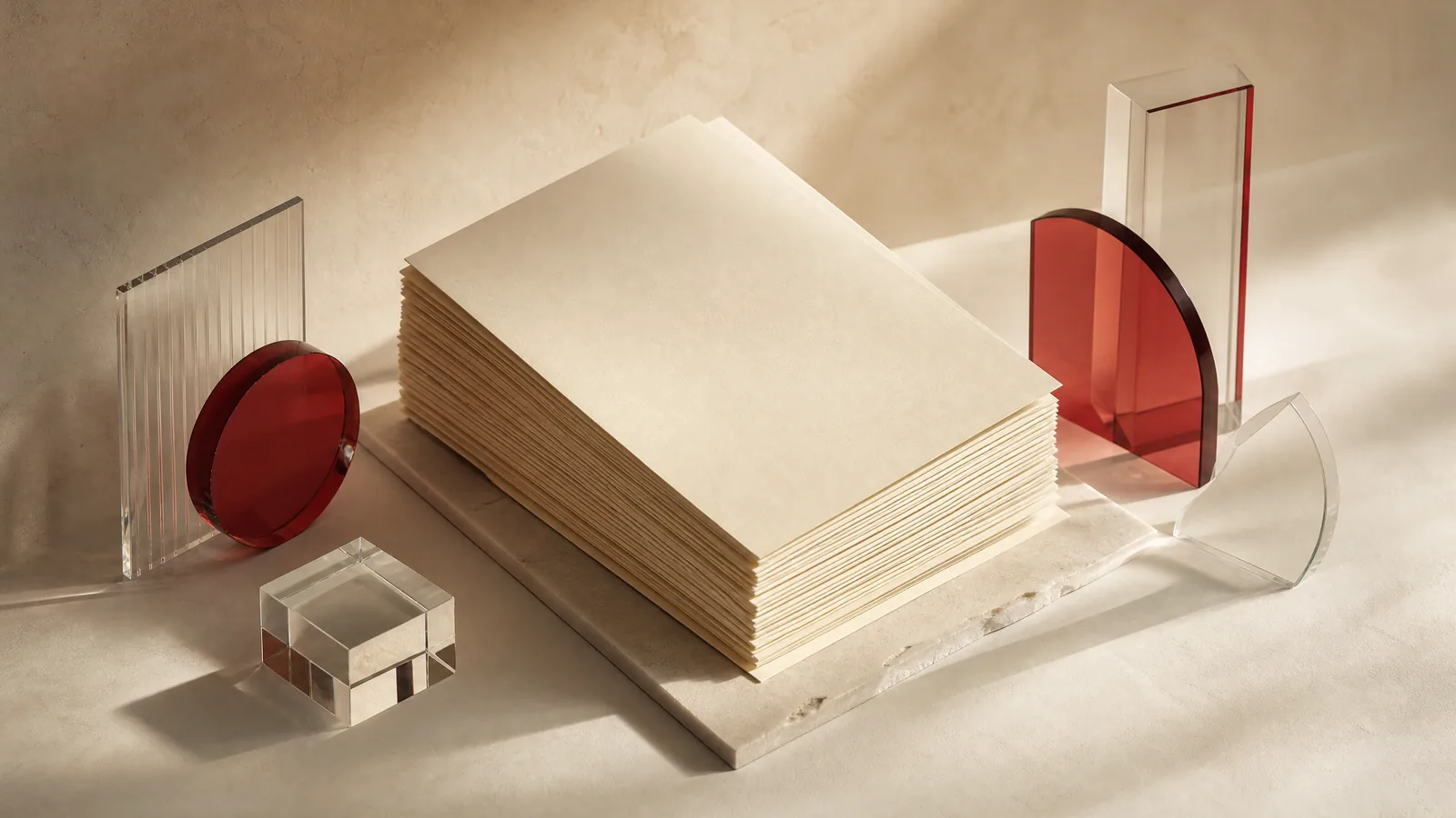 An ivory paper stack and geometric glass shapes